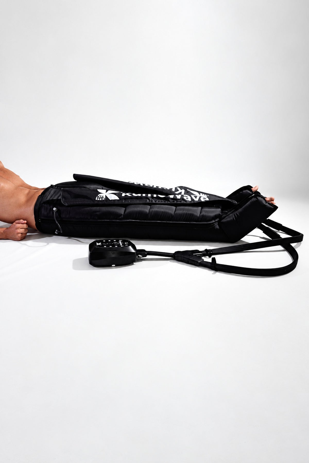 KumoWave Elite, pantalón de presoterapia con las cámaras hinchadas y la unidad de control, vista lateral
